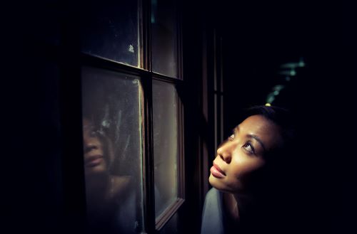 Girl looking out window feeling lost